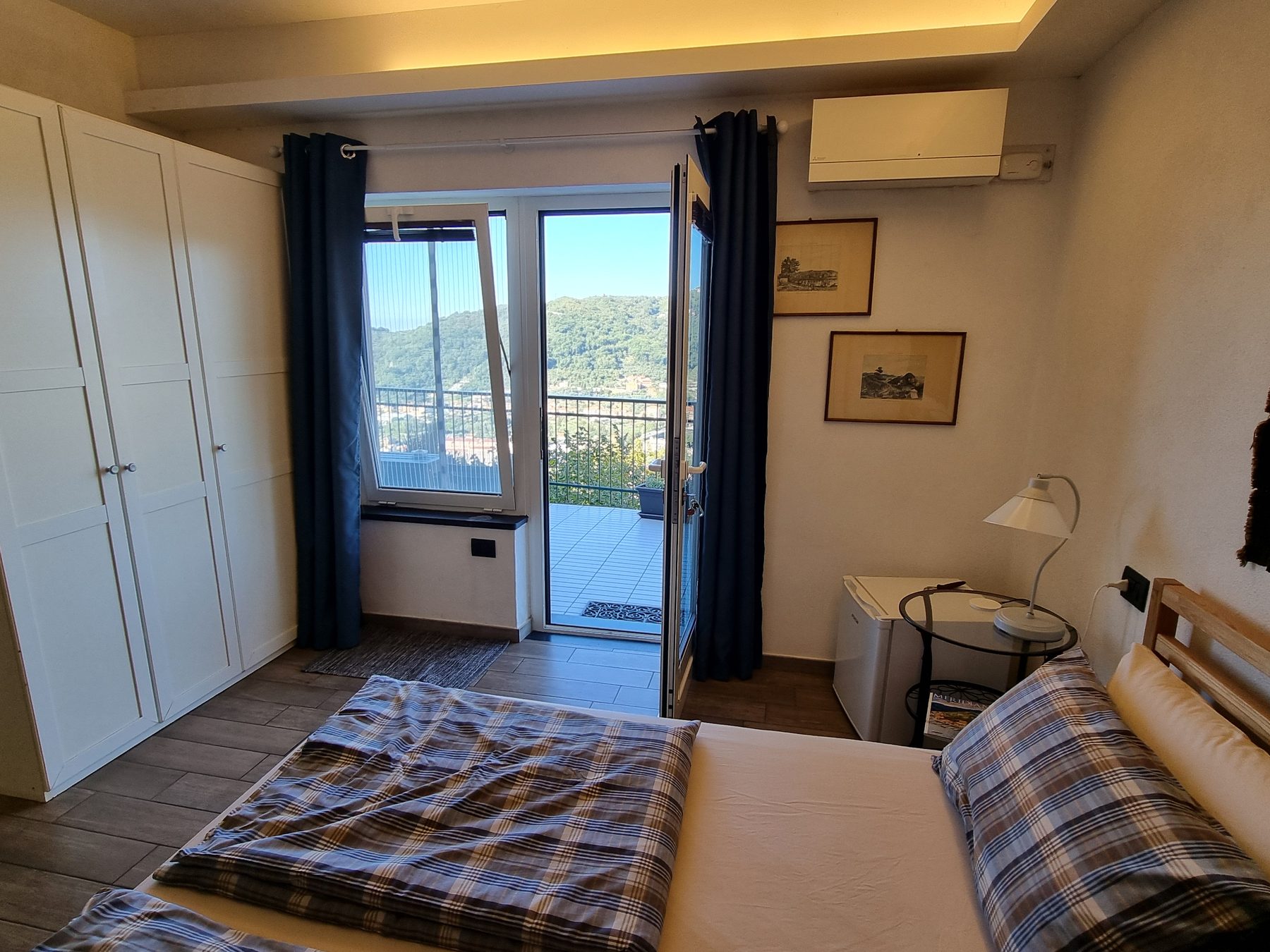 Das Zimmer Tigullio mit Doppelbett und Glastür zur kleinen Terrasse